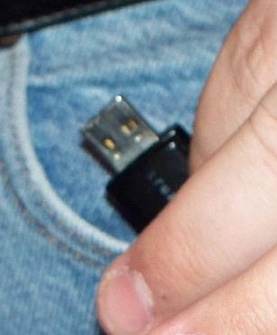 A USB stick being tucked into someone's pocket.