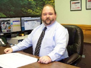 Geof sitting behind his desk at the office.