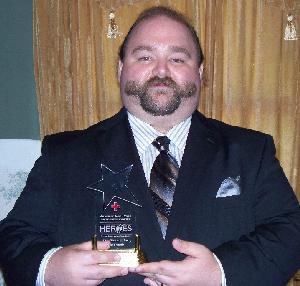 Geof holding his Hometown Hero Award.