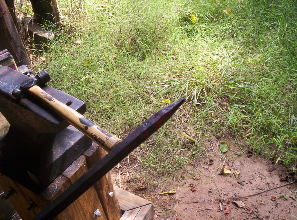 A point has been hammered into the stock. In the background a hammer rests on the anvil.