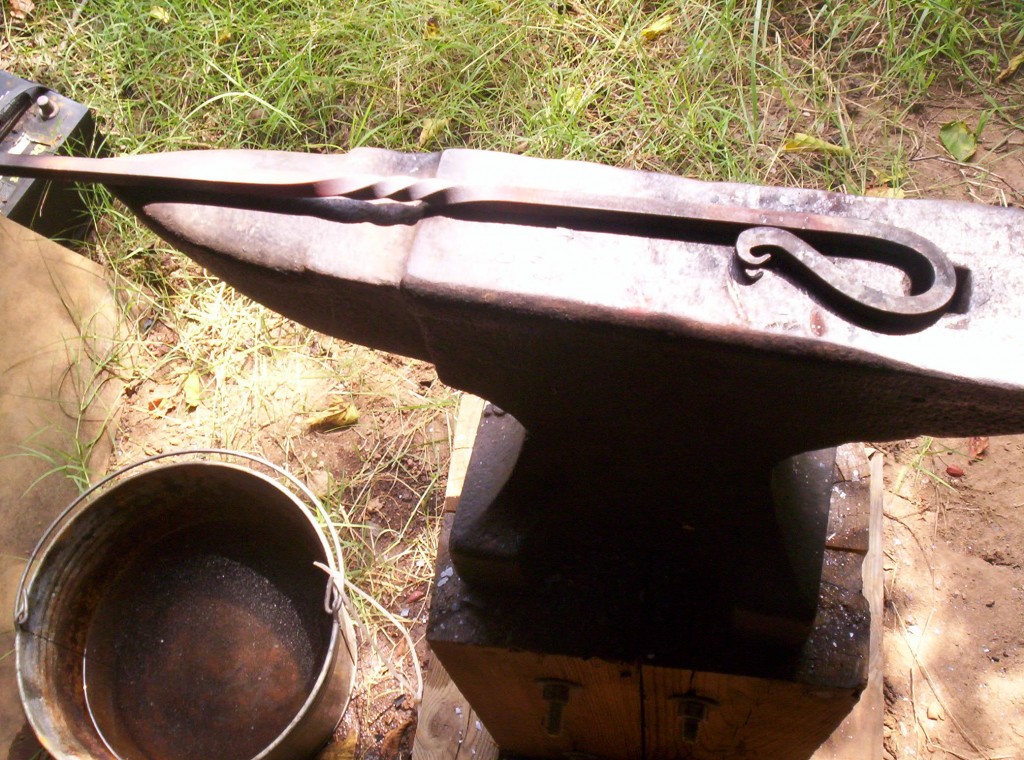 The fire hook sits on the anvil, a small letter G is visible near the curved handle.