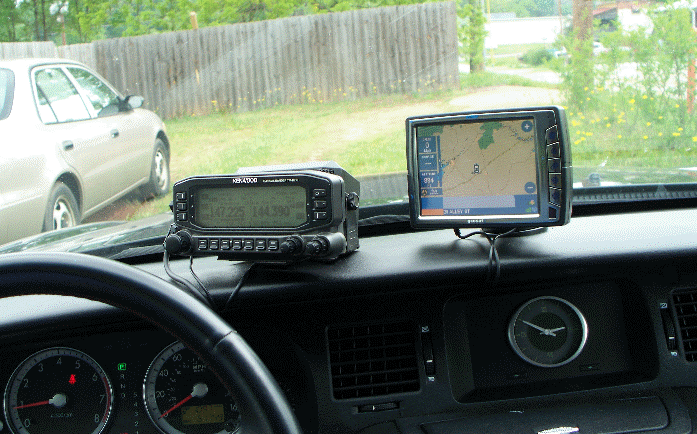 A photograph from the driver's seat looking at a radio control head and a GPS device.