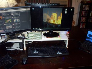 Two computer monitors, keyboard and mouse on Geof's desk.