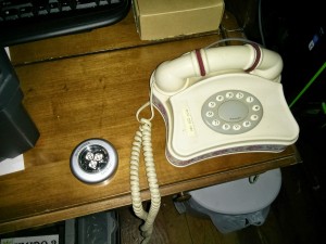 A corded telephone sitting on a shelf.