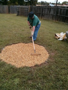 Geof smoothing pea gravel in the firepit with a rake.